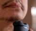 Man shaving stubble from his chin with a foil shaver.